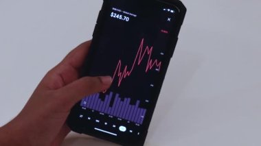 Woman looking through BNB 1 week chart on Black smartphone