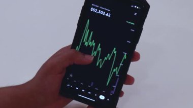 Woman looking through BTC 2 Years chart on Black smartphone