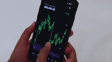 Woman looking through BTC 3 Months chart on Black smartphone
