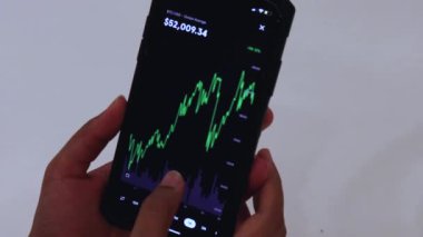 Woman looking through BTC charts on phone