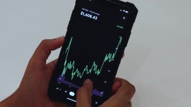 Woman looking through Etherium charts on cellphone
