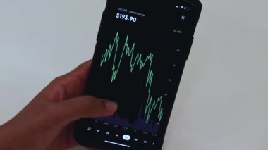 Woman looking through LTC 3 Days chart on Black smartphone