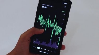 Woman looking through USDT 1 Month chart on Black smartphone