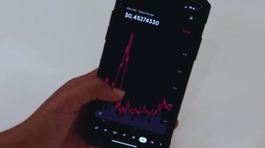  Woman looking through XRP 1 week chart on Black smartphone