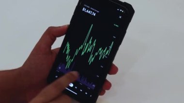 Woman looking through ETH charts on cellphone