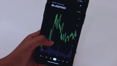  Woman looking through XRP 6 Months chart on Black smartphon