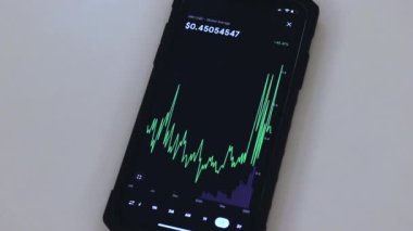 XRP chart on a black phone placed on a white table