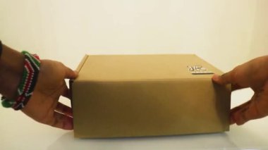 Bir kadın tarafından bir masaya konan kutu.