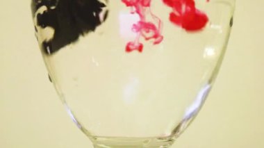 Color Dyes Being Added Into Wine Glass - Pink And Black