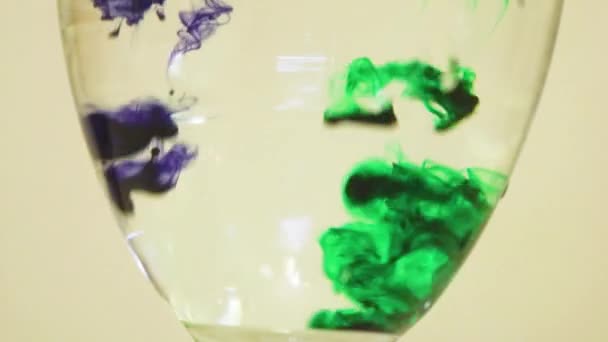 Color Dyes Being Added Into Wine Glass - Violet And Green