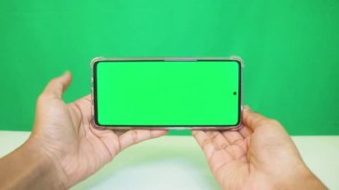Yeşil ekranlı cep telefonu kullanan kadın eller 