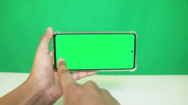 Yeşil ekranlı cep telefonu kullanan kadın eller 