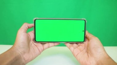 Yeşil ekranlı cep telefonu kullanan kadın eller 