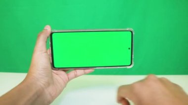 Yeşil ekranlı cep telefonu kullanan kadın eller 