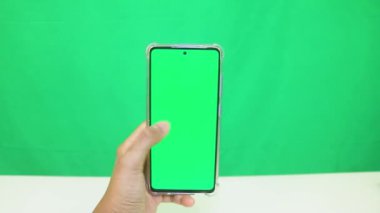 Yeşil ekranlı cep telefonu kullanan kadın eller 