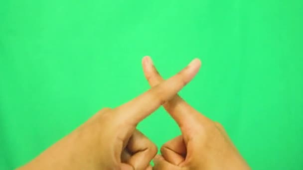 女性在绿色背景下做手势的特写 手指X — 图库视频影像
