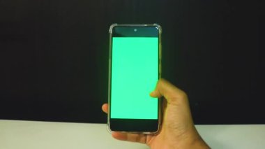 Yeşil ekranlı cep telefonu kullanan kadın eller 