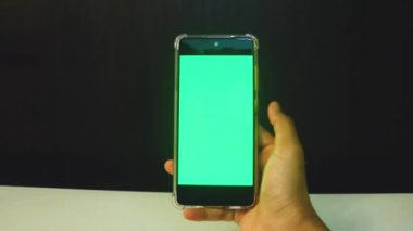 Yeşil ekranlı cep telefonu kullanan kadın eller 