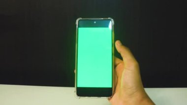 Yeşil ekranlı cep telefonu kullanan kadın eller 
