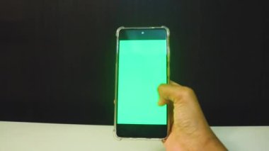 Yeşil ekranlı cep telefonu kullanan kadın eller 