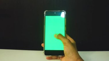 Yeşil ekranlı cep telefonu kullanan kadın eller 