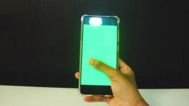 Yeşil ekranlı cep telefonu kullanan kadın eller 