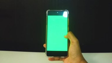 Yeşil ekranlı cep telefonu kullanan kadın eller 