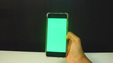 Yeşil ekranlı cep telefonu kullanan kadın eller 
