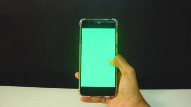 Yeşil ekranlı cep telefonu kullanan kadın eller 
