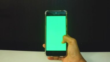 Yeşil ekranlı cep telefonu kullanan kadın eller 