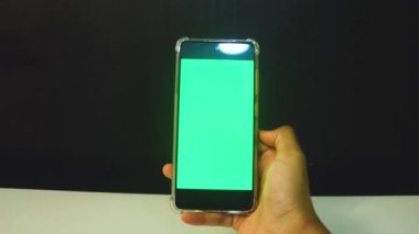 Yeşil ekranlı cep telefonu kullanan kadın eller 