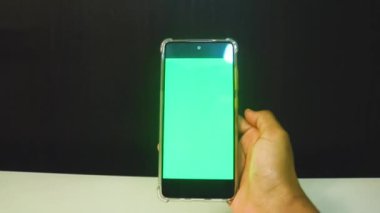 Yeşil ekranlı cep telefonu kullanan kadın eller 