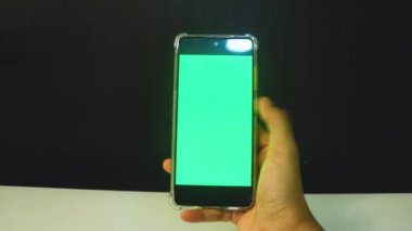 Yeşil ekranlı cep telefonu kullanan kadın eller 
