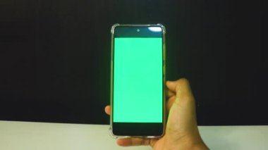 Yeşil ekranlı cep telefonu kullanan kadın eller 