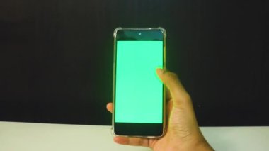 Yeşil ekranlı cep telefonu kullanan kadın eller 