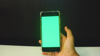 Yeşil ekranlı cep telefonu kullanan kadın eller 