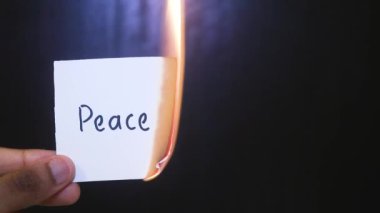 Kağıtları elinde tutan kişinin yakın plan görüntüsü Alevler içinde yanan kelimelerle