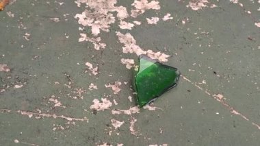 Hasarlı bir zeminde kırık camlarla eski basketbol sahası
