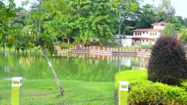 Park Area With A Lake And People On A Bridge