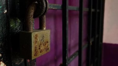 Üzerinde kırmızı duvar yazısı ve paslı bir kilit olan duvar.