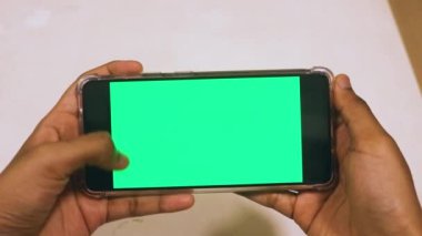 Yeşil ekranlı cep telefonu kullanan kadın eller 
