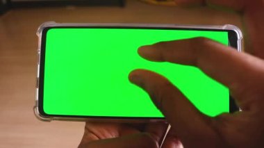 Yeşil ekranlı cep telefonu kullanan kadın eller 