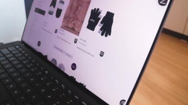 Kadın bölümünden kıyafet alışverişi yapıyor. Eldivenler
