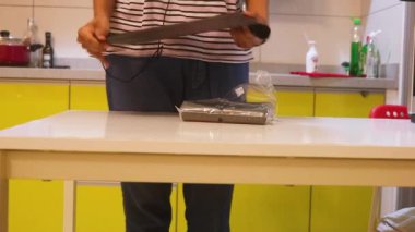 Ethnic Woman Taking A Trash Bag From A White Table