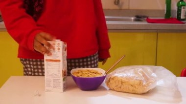 Müslüman kadın mısır gevreği için süt kutusu açıyor..