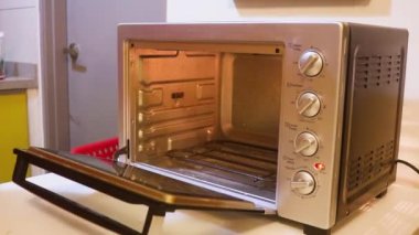 Mini fırına çiğ patates koyan Müslüman Kadın