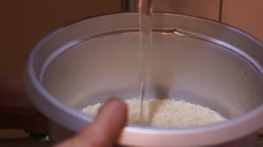 Rice Being Washed In A Pot By Ethnic Woman