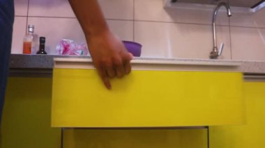 Tanned Woman Getting Knife And Peeler From Drawer