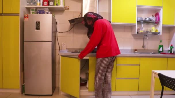 Μουσουλμανική Κυρία Άνοιγμα Cupboards Μια Κουζίνα Ευρεία Shot — Αρχείο Βίντεο