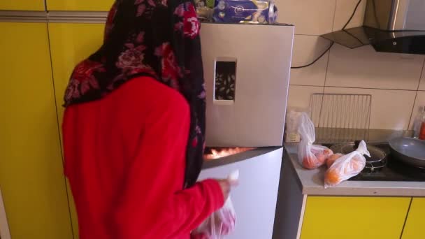 Muslimische Frau Legt Tüten Mit Früchten Kühlschrank — Stockvideo